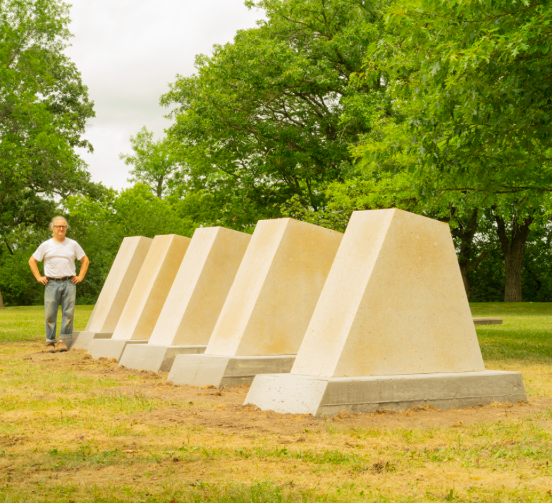 Sculptor Pete Driessen stands by his piece titled "Wind Dam."